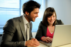 Man and woman looking positive at the prospect of getting a job interview.